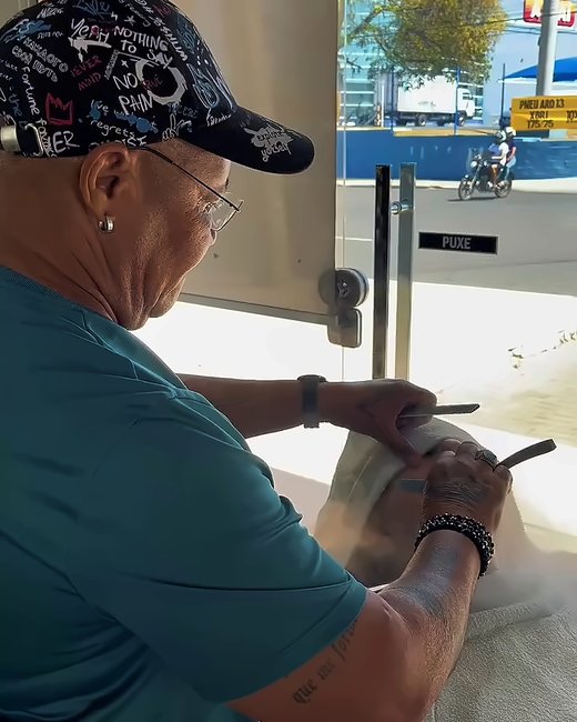 Barbeiro fazendo a barba na navalha