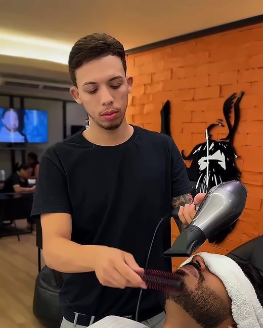 Barbeiro secando o cabelo do cliente depois da lavagem