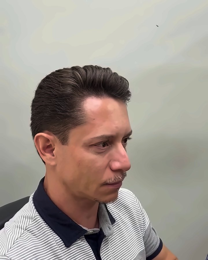 Cliente de perfil com o corte finalizado, penteado para trás